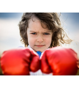 Kid wearing red boxing gloves. Girl power and feminism concept