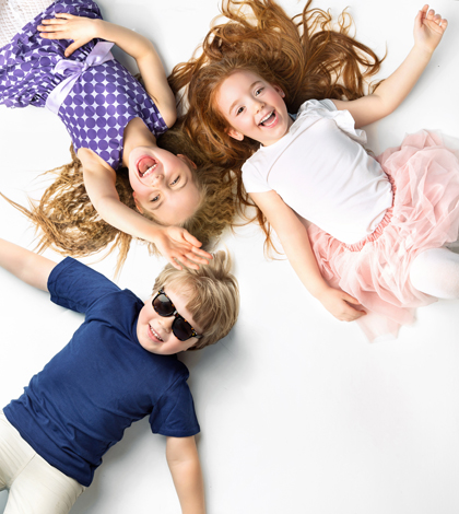 Portrait of little siblings lying on a white background